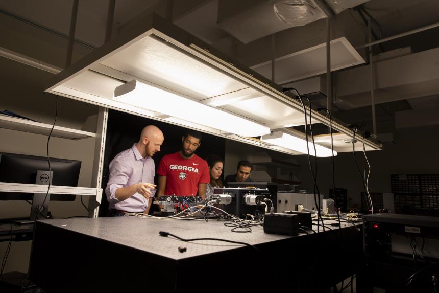 Graduate Students work in the laboratory with equipment used for nanoscale imaging & spectroscopy.