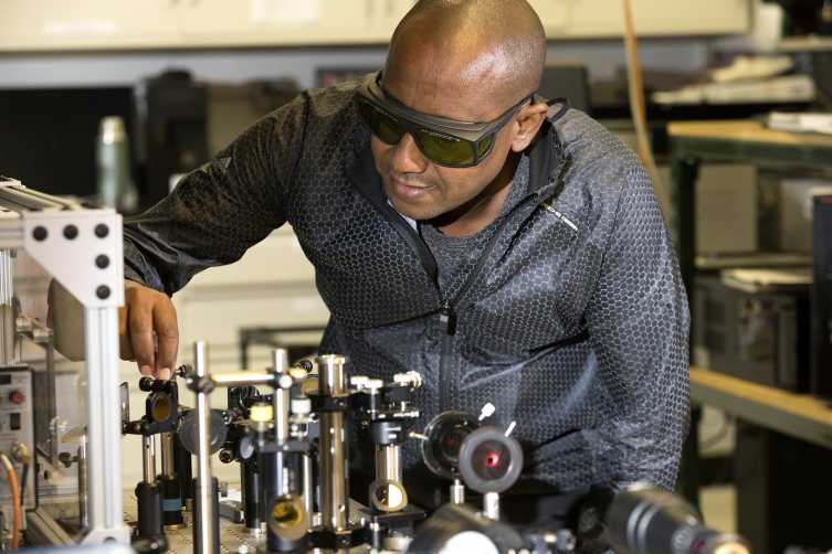 Professor Yohannes Abate works with nano optic technology inside of a laboratory. (Photo by Andrew Davis Tucker/UGA)